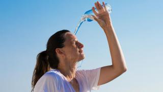 Una mujer echándose agua.