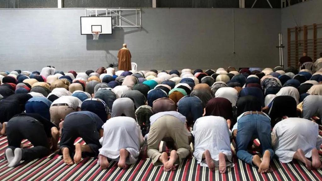 Musulmanes celebran la fiesta del sacrificio del cordero en una cancha de baloncesto.