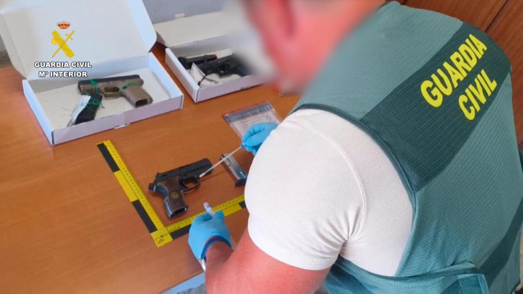 La Guardia Civil analiza un arma de los sospechosos.