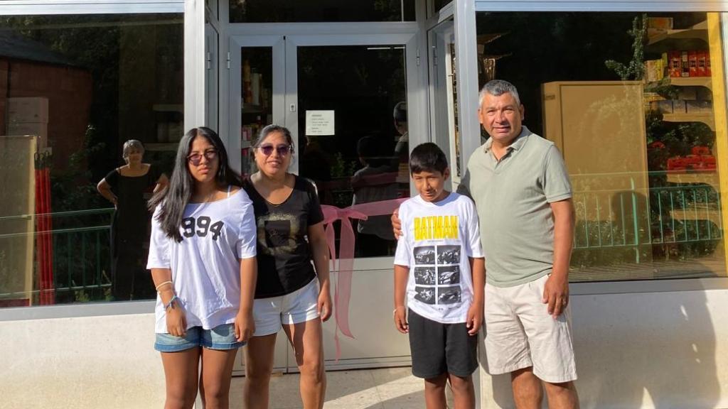Jeny Quispe junto a su marido y sus hijos a las puertas de su nuevo negocio en un pueblo de León