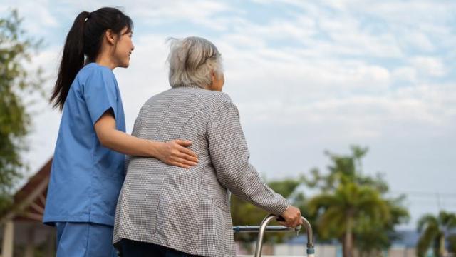 Una trabajadora de ayuda a domicilio junto a una mujer mayor.