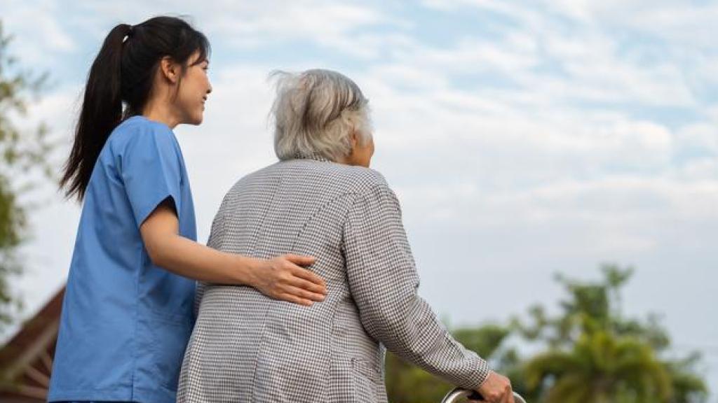 Una trabajadora de ayuda a domicilio junto a una mujer mayor.