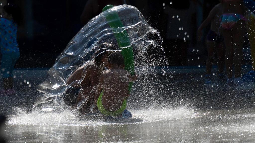 Niños se refrescan en un parque de Torrelavega.