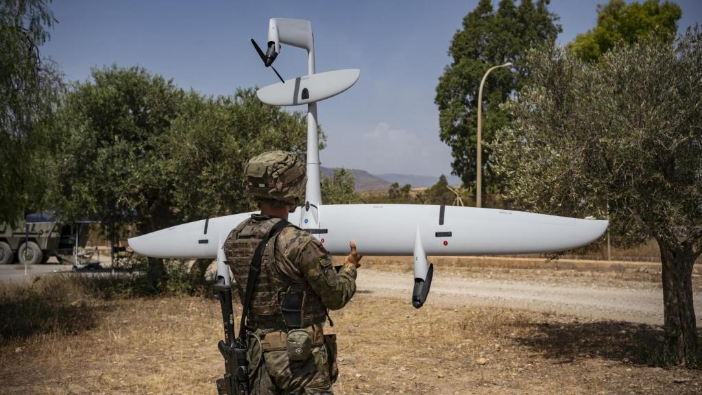 Un soldado español mantiene el Dron Vector tras el aterrizaje del VTOL de vigilancia