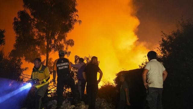 Varias personas tratan de extinguir el fuego, a 5 de agosto de 2025, en Ponteceso, A Coruña, Galicia (España).