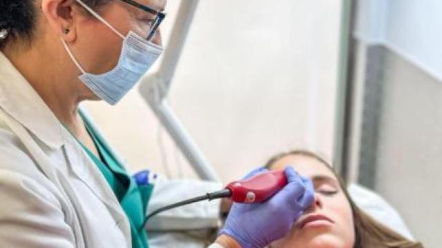 La doctora Soria aplicando el láser en uno de los puntos vitales de la cabeza.