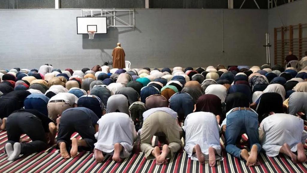 Musulmanes celebran la fiesta del sacrificio del cordero en una cancha de baloncesto.