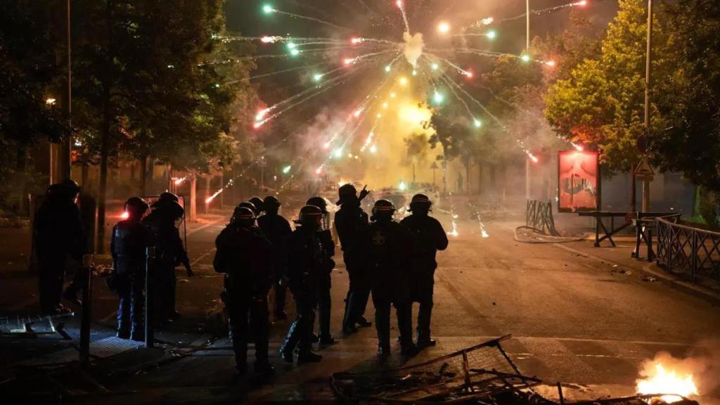 La policía francesa permanece a la espera mientras explota material en unos disturbios en 2023 en Nanterre, la localidad de la 'banlieue' al noroeste de París.