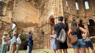 Turistas durante la visita guiada al Monasterio de Granja de Moreruela, junto a Víctor López de la Parte