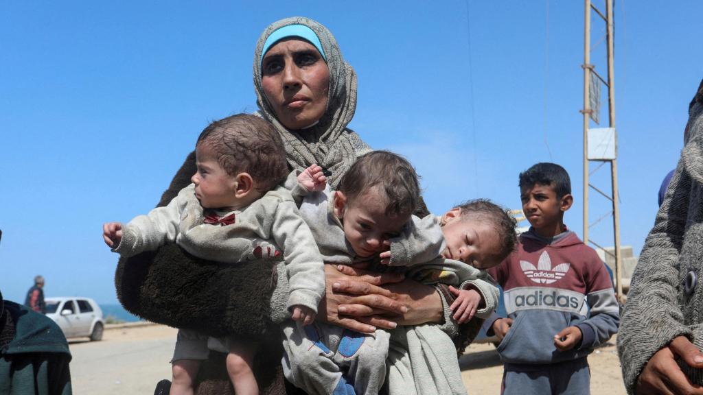 La mujer palestina Nozha Awad huye con sus trillizos del hospital Al Shifa de Gaza tras un ataque israelí. Foto: Reuters/Ramadan Abed