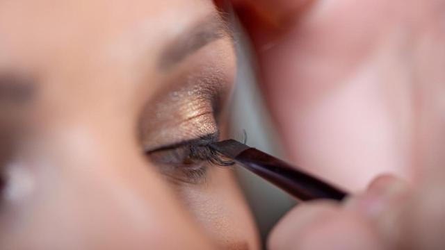 Imagen de archivo de una mujer pintándose el ojo.