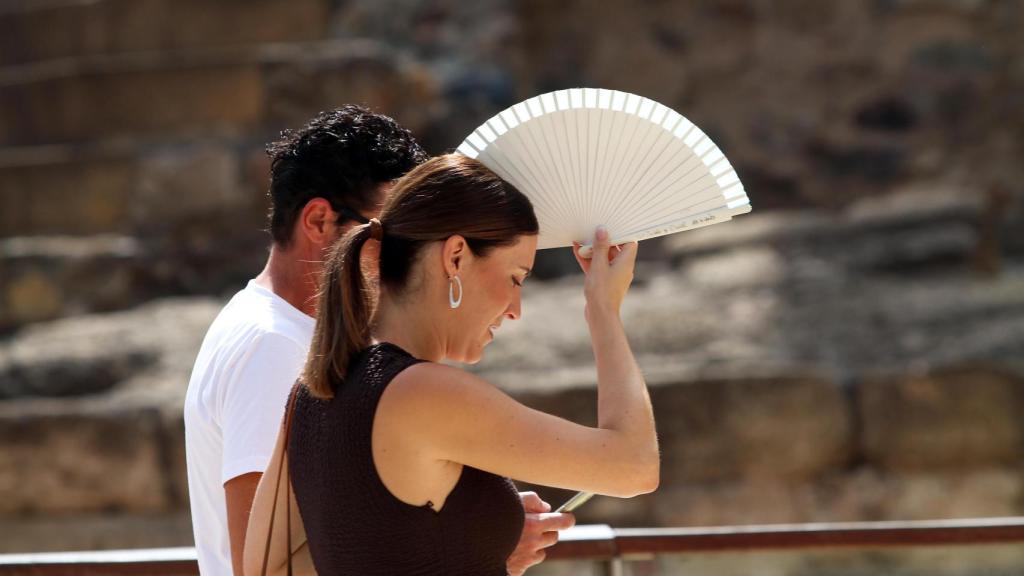 Imagen de dos viandantes con un abanico.