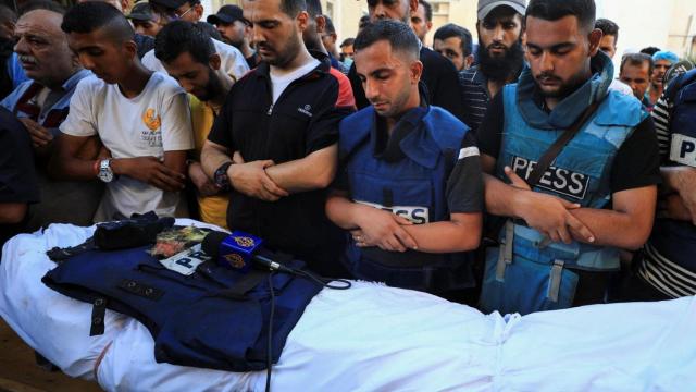 El periodista Anas Al Sharif, quien murió en un ataque israelí el 10 de agosto de 2025, reza junto al cuerpo de su colega, el reportero de Al Jazeera Ismail al-Ghoul, muerto en julio de 2024.