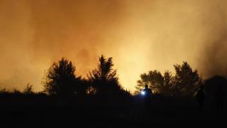 Un hombre, en estado crítico con Un agente de Policía local evacúa a personas en el incendio que se ha declarado en la tarde de este lunes en la localidad madrileña de Tres Cantos  en el 98% de su cuerpo en el incendio de Tres Cantos