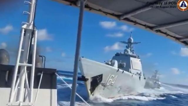 El destructor chino, con un pequeño daño en la proa, y al fondo el barco de la Guardia Costera.