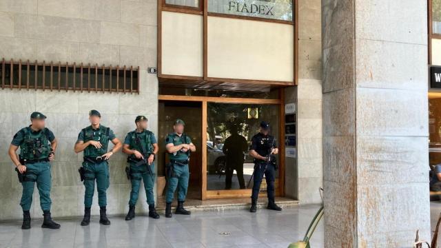 Agentes de la Guardia Civil y la Policía Nacional desplegados frente a un edificio en Palma en el marco de una operación contra el blanqueo de capitales.