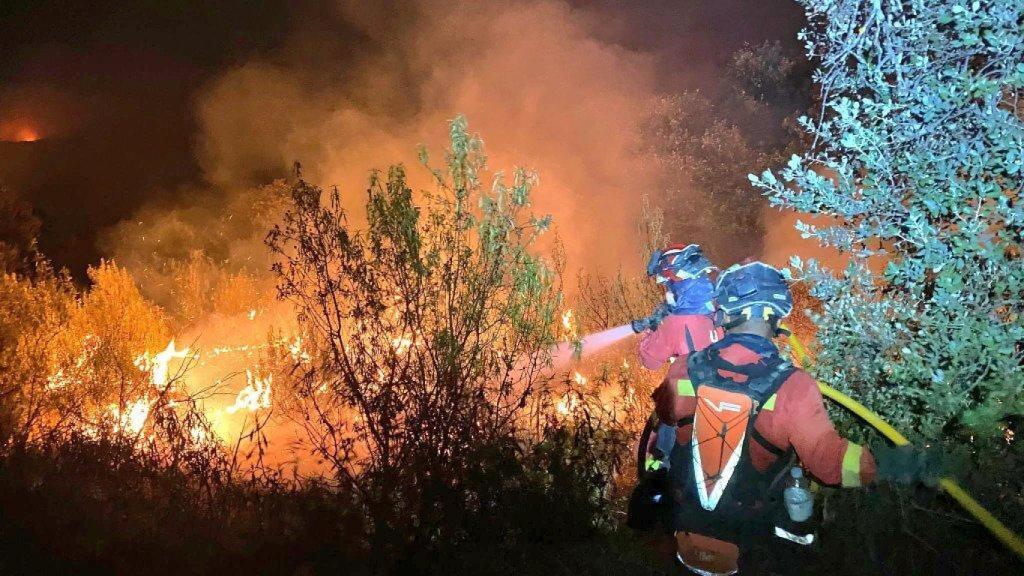 Bomberos intentan apagar las llamas del incendio de Tres Cantos (Madrid).