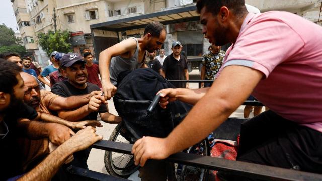 Palestinos cargan con heridos tras un ataque aéreo israelí en la ciudad de Gaza.