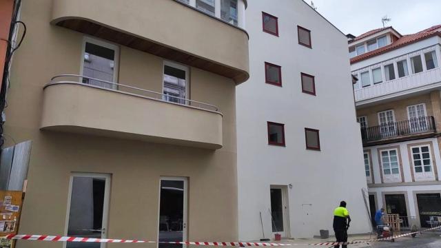 Dos obreros limpian el lateral del edificio de Marqués de Pontejos tras la retirada de las vallas.