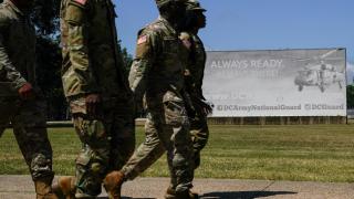 Personal militar estadounidense camina frente al D.C. Armory tras el anuncio del presidente Donald Trump de desplegar a la Guardia Nacional en Washington.