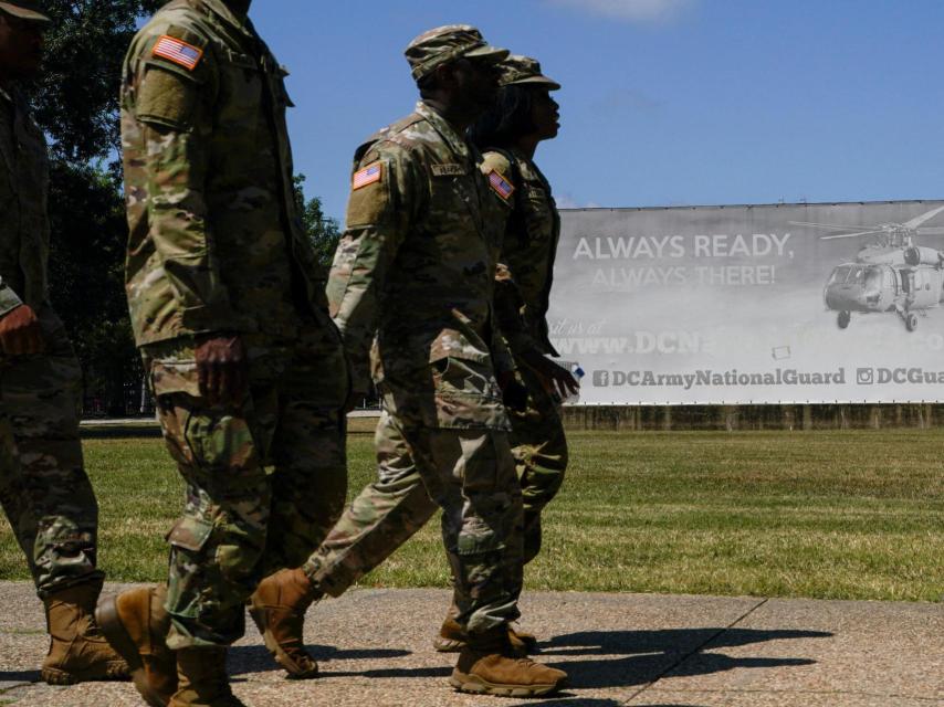 Personal militar estadounidense camina frente al D.C. Armory tras el anuncio del presidente Donald Trump de desplegar a la Guardia Nacional en Washington.