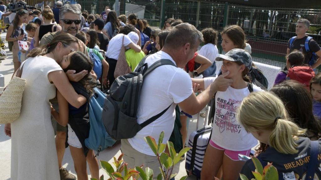 Varios niños abrazan a familiares, en el parque acuático de Monterrei