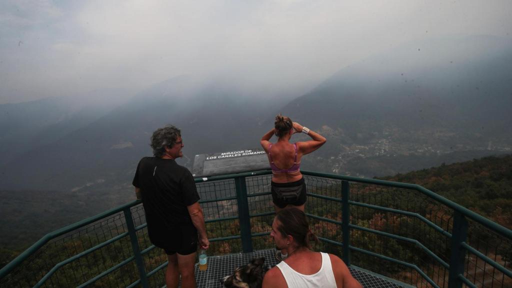 Tres personas observan el incendio cercano a la localidad de Pombriego (León).