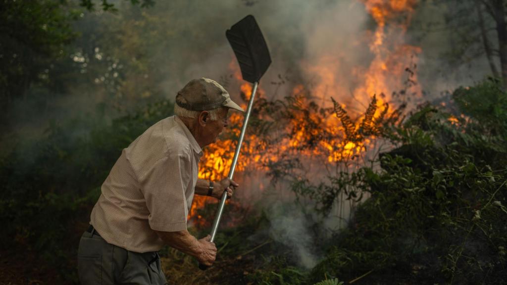 Un vecino de la aldea de Pareisás lucha contra en fuego en el incendio forestal que permanece activo en A Pobra de Trives (Ourense).