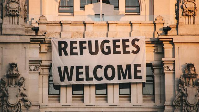 Bienvenida a los refugiados bandera colgada en el edificio del Ayuntamiento de Madrid.