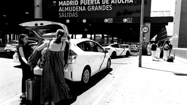Varias personas con maletas suben a un taxi en el exterior de la estación Puerta de Atocha-Almudena Grandes, durante la primera operación salida del verano 2025, a 27 de junio de 2025, en Madrid (España).