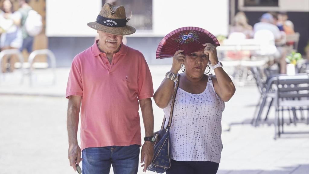Dos personas se protegen del calor en una foto de archivo.