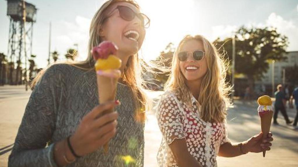 Imagen de archivo de dos chicas disfrutando mientras se comen unos helados.