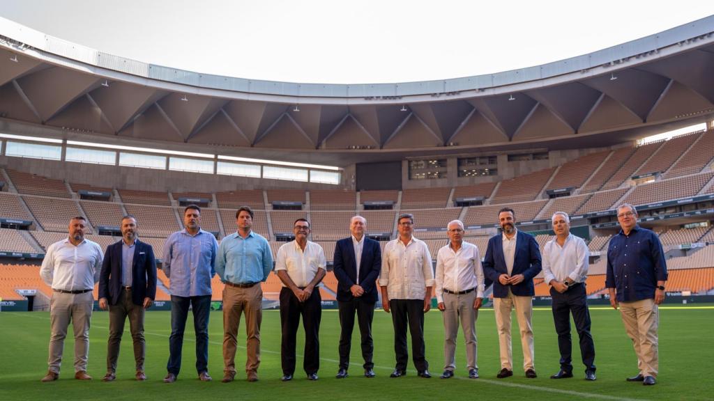 Representantes del Betis posan en el césped de La Cartuja junto a las instituciones implicadas en el plan de movilidad.