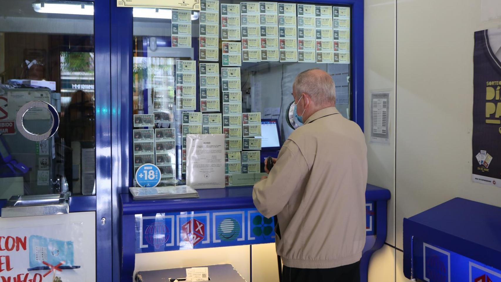 Un hombre compra lotería en una Administración de Lotería