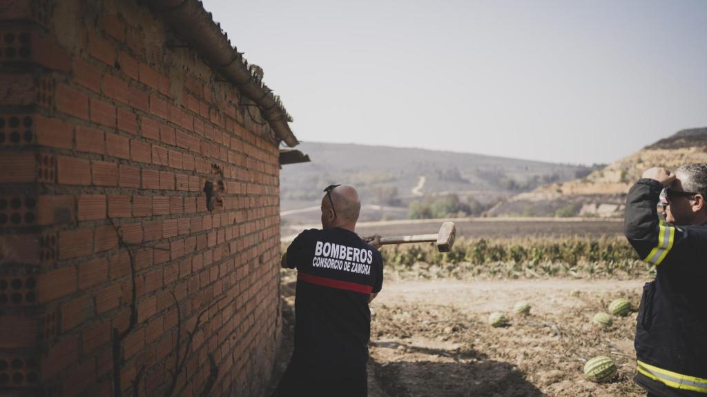 Mario Luego, coordinador operativo de parques del consorcio de bomberos de Zamora, rompe el ladrillo para ventilar la nave.