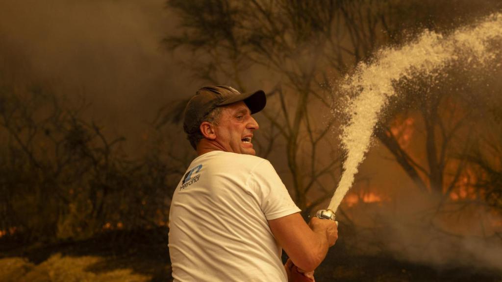 Vecinos de la aldea de Lamas (Cualedro) intentan aplacar el fuego que afecta este viernes esta zona de Ourense.