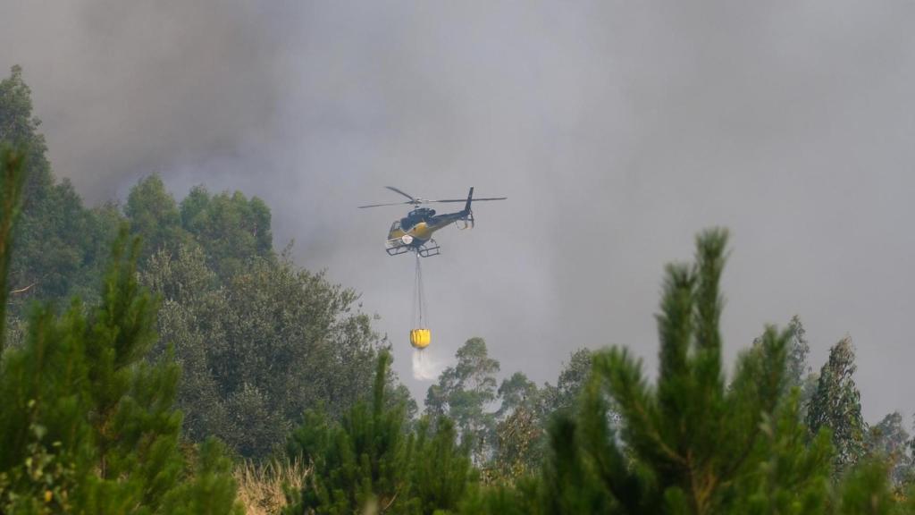 Un helicóptero en plenas tareas de extinción, en Penagundín, en Melide (A Coruña)