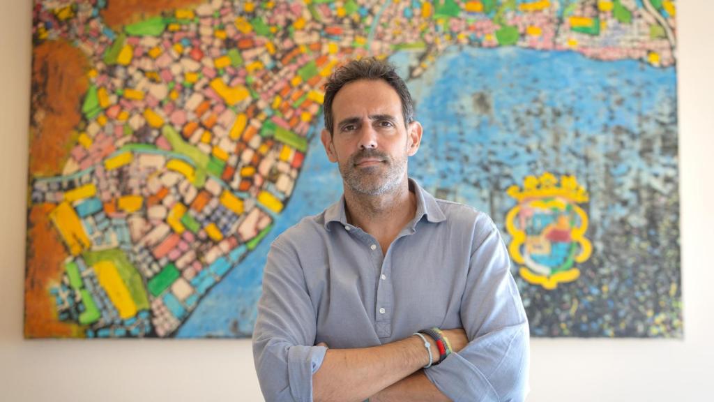 Javier Frutos delante de un mapa de Málaga.