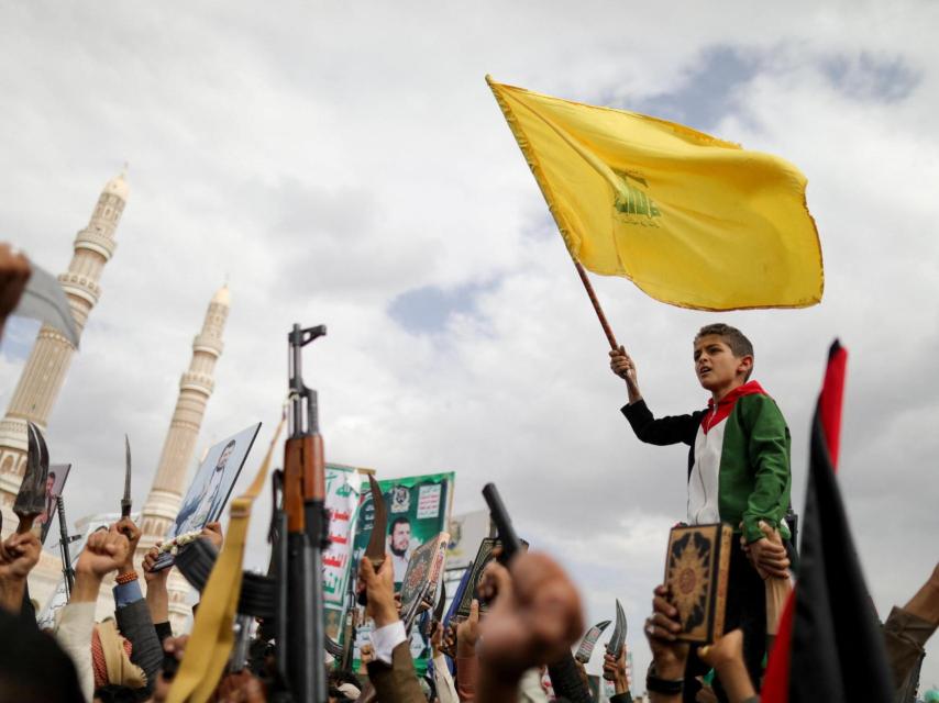 Un niño ondea la bandera de Hezbolá en mitad de una manifestación propalestina en Saná (Yemen).