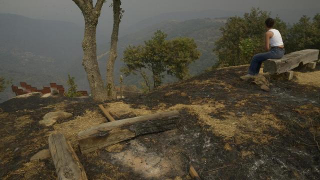 Vecinos contemplan el efecto de los incendios en Ourense.