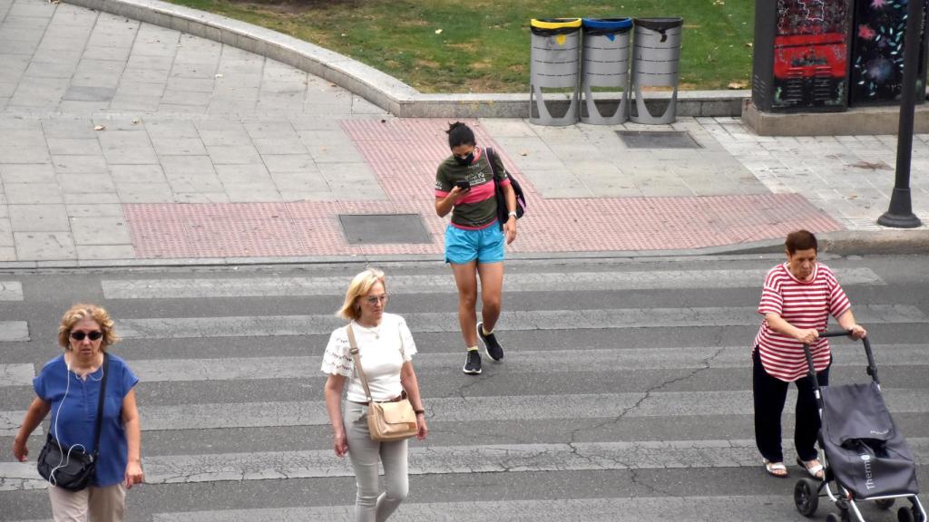 Una mujer con mascarilla cruza el paso de peatón de la Farola con mascarilla
