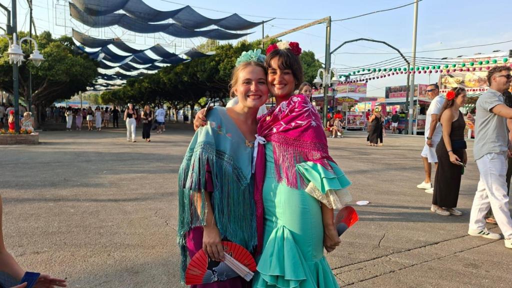 Dos jóvenes vestidas con trajes de flamenca en la Feria de Málaga.
