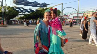 Dos jóvenes vestidas con trajes de flamenca en la Feria de Málaga.