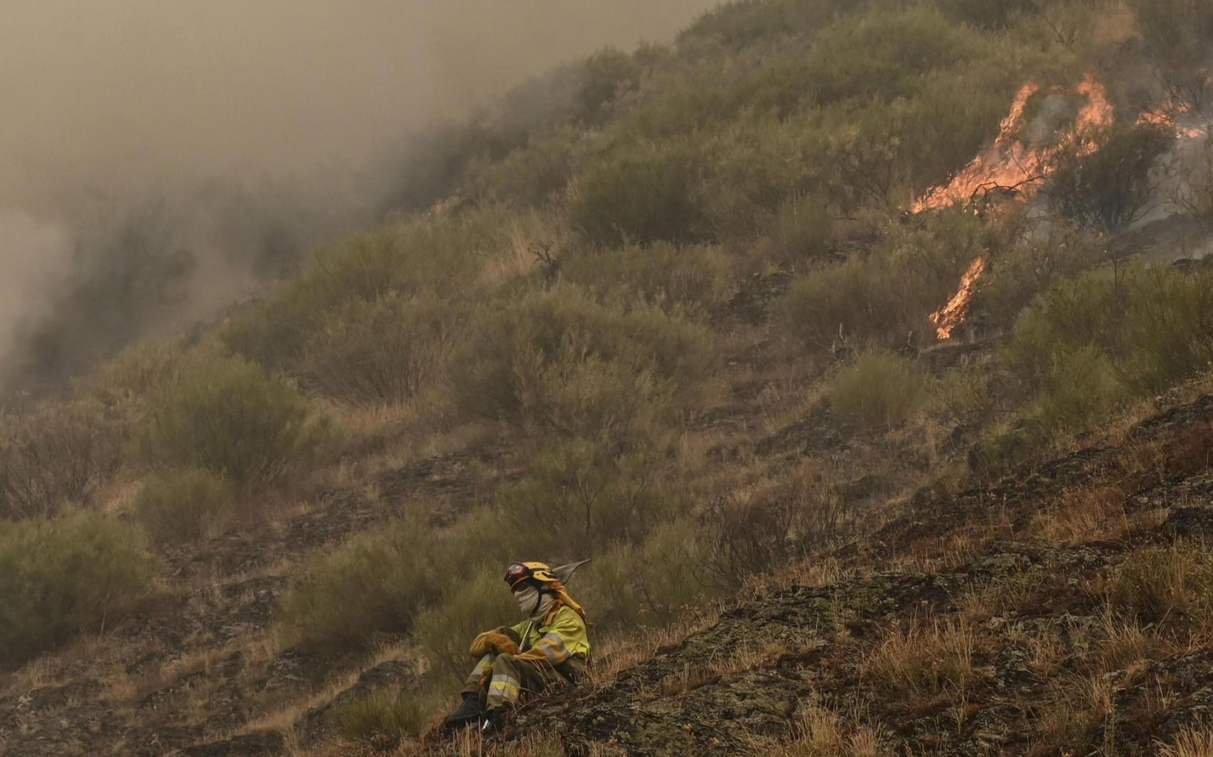 Una persona que lucha contra el fuego muestra su desesperación ante el incendio que amenaza la vertiente leonesa del Parque Nacional de Picos de Europa.