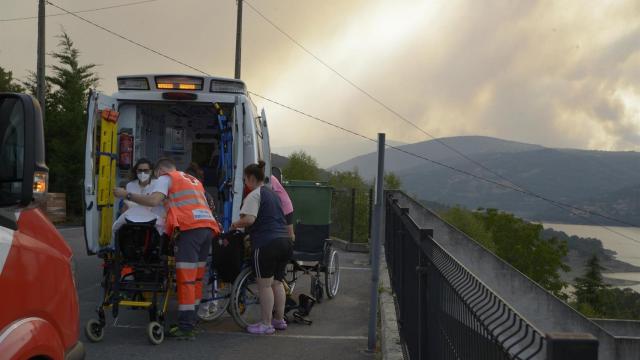 Traslado de ancianos de la residencia de mayores de Celeiros por un convoy de ambulancias y turismos de Cruz Roja, a causa del posible peligro por el incendio en Celeiros, a 13 de agosto de 2025, en Chandrexa de Queixa, Ourense