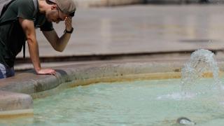 Un hombre echándose agua en una fuente en una imagen de archivo.