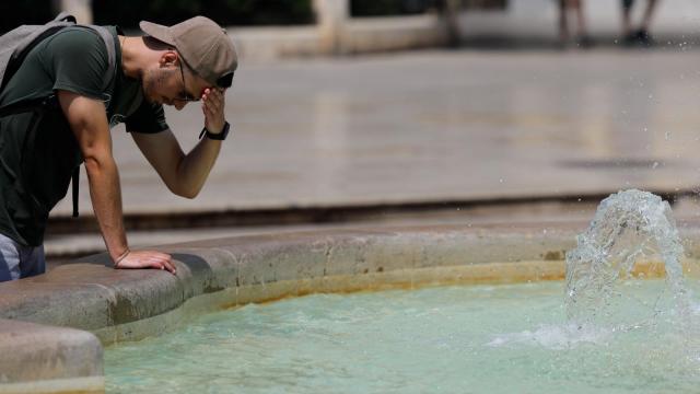 Un hombre echándose agua en una fuente en una imagen de archivo.