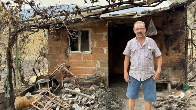 Ángel Gil, vecino de Jarilla, el epicentro del mayor incendio que arrasa en Extremadura, posa para EL ESPAÑOL en la puerta de su casa, aún con cenizas.