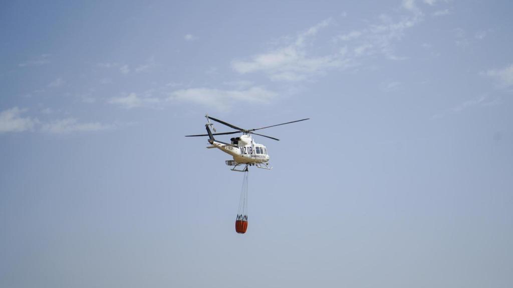 Fotografía tomada desde el Valle del Jerte (Palacio de la Cereza, en Valdastillas) de un helicóptero que se dirige al frente de un incendio que avanza hacia Segura de Toro.