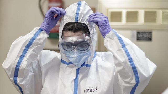 Una sanitaria, poniéndose el equipo de protección contra la Covid-19 en 2020.